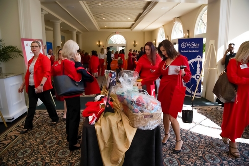 Photo of ladies in red browsing items on a table