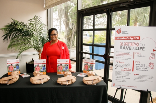 Photo of lady in red standing at CPR Hands Only Display Table